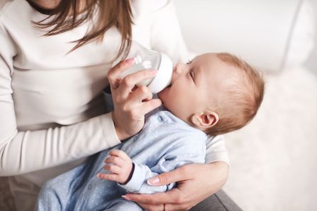 Mutter stillt Baby mit eine Fläschchen Muttermilch