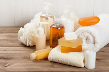 Tisch mit Handtüchern, Waschschwämmen, Seifen, Crems, Shampoo, Duschgel und weiteren Pflegeprodukten für Körper und Gesicht