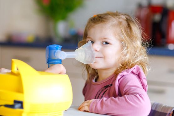 Mädchen sitzt vor einem Inhalationsgerät