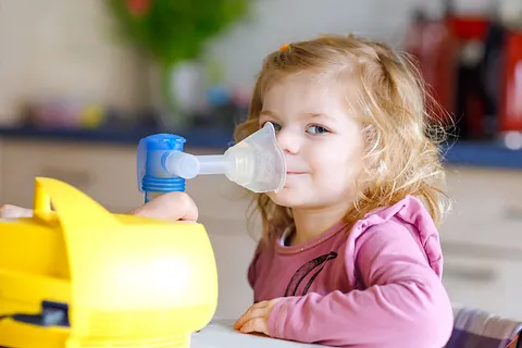 Mädchen sitzt vor einem Inhalationsgerät